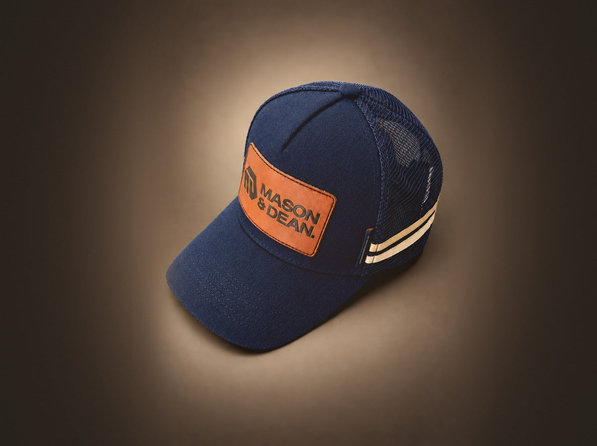 Navy Mason & Dean trucker cap with tan leather logo patch and cream side stripes